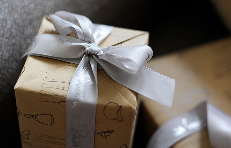 A small gift box wrapped with a silver ribbon.